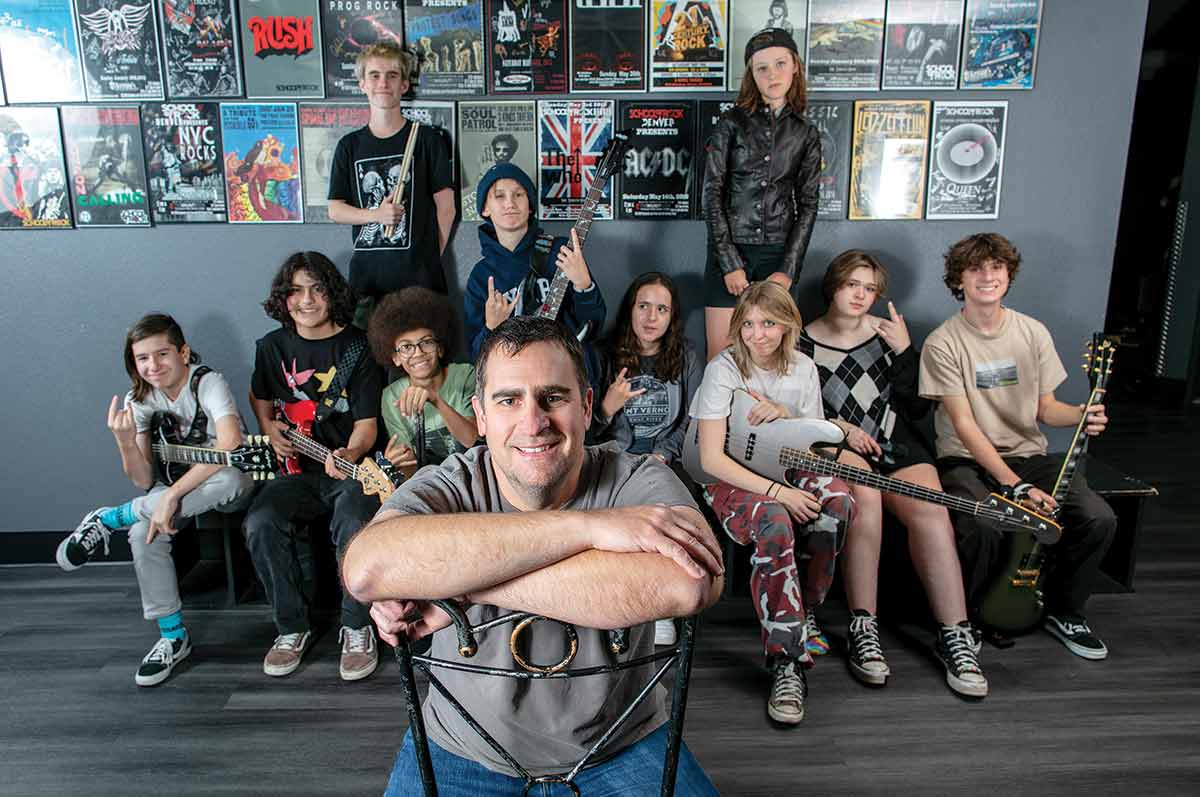 Jim Johnson sits down in front of his students from the School of Rock