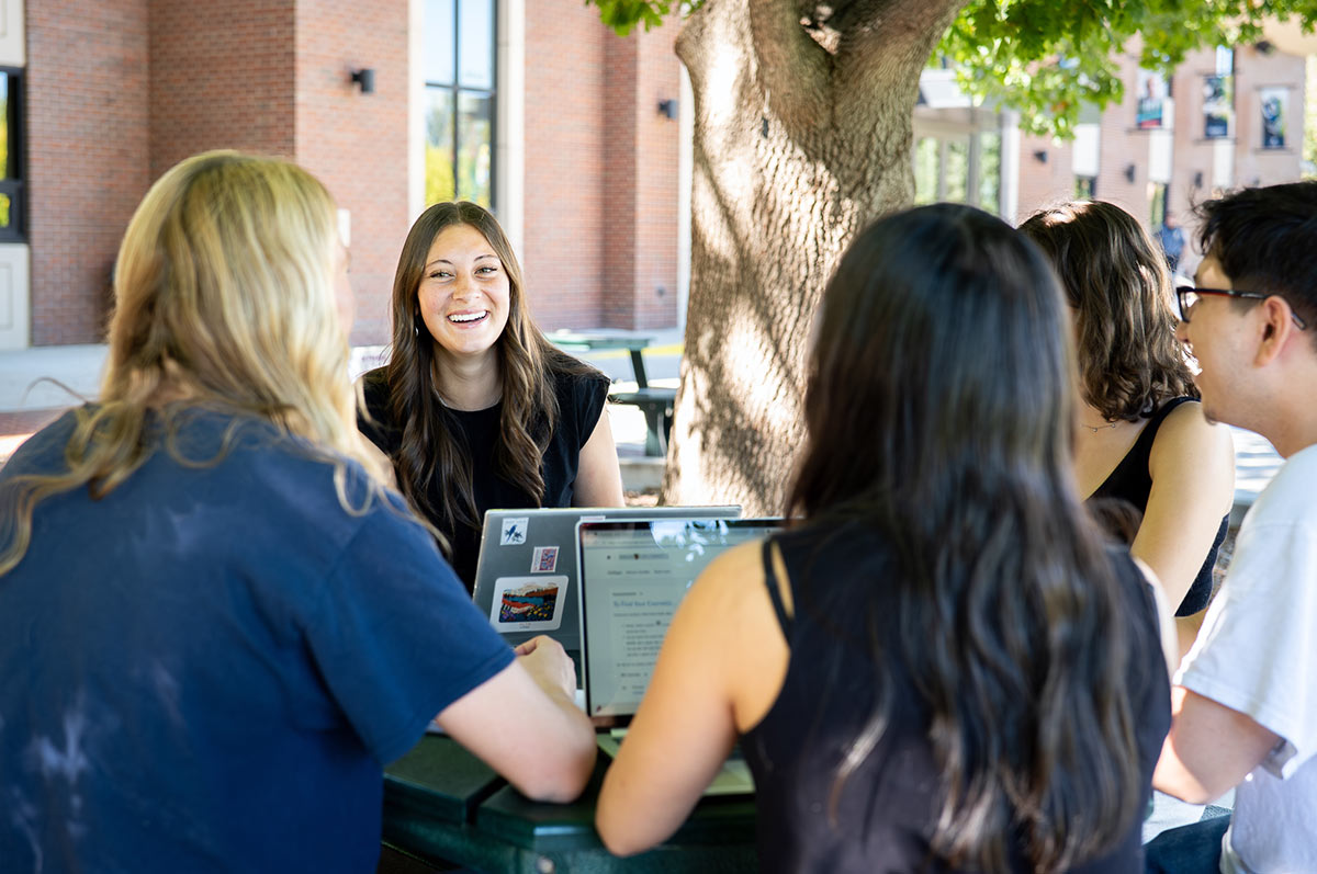 a group of college students networking with peers outside the student center on the Regis campus