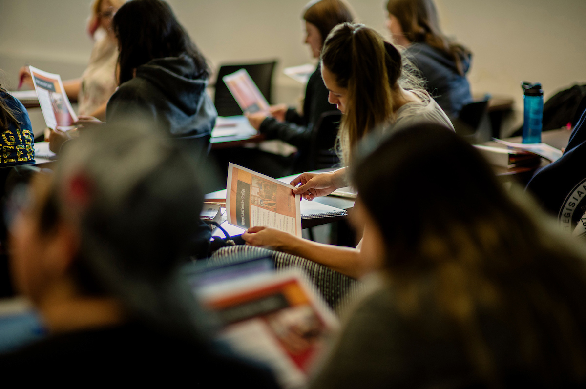 Regis University students review literature in a classroom