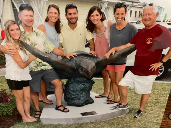 The Witchger family poses with a sea turtle statue outdoors